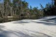 A sandy beach along the Perdido River in Alabama. Trees line the opposite bank.