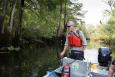 USFWS biologist piloting a boat looking for Gulf Sturgeon in their river habitat.