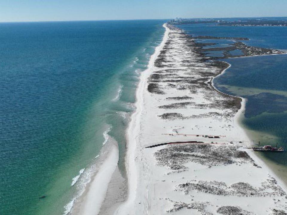 ocean is on either side of a long sand island 