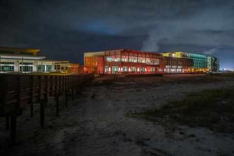 The award-winning Gulf State Park at night. A boardwalk and dunes in the foreground.