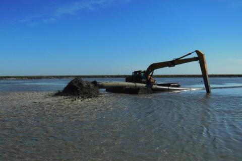 An excavator moves dredged sediment at a Louisiana marsh creation project. Image: CWPPRA