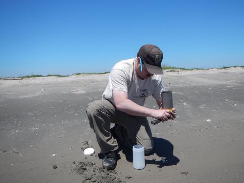 A USFWS biologist takes samples of sand at North Breton Island.